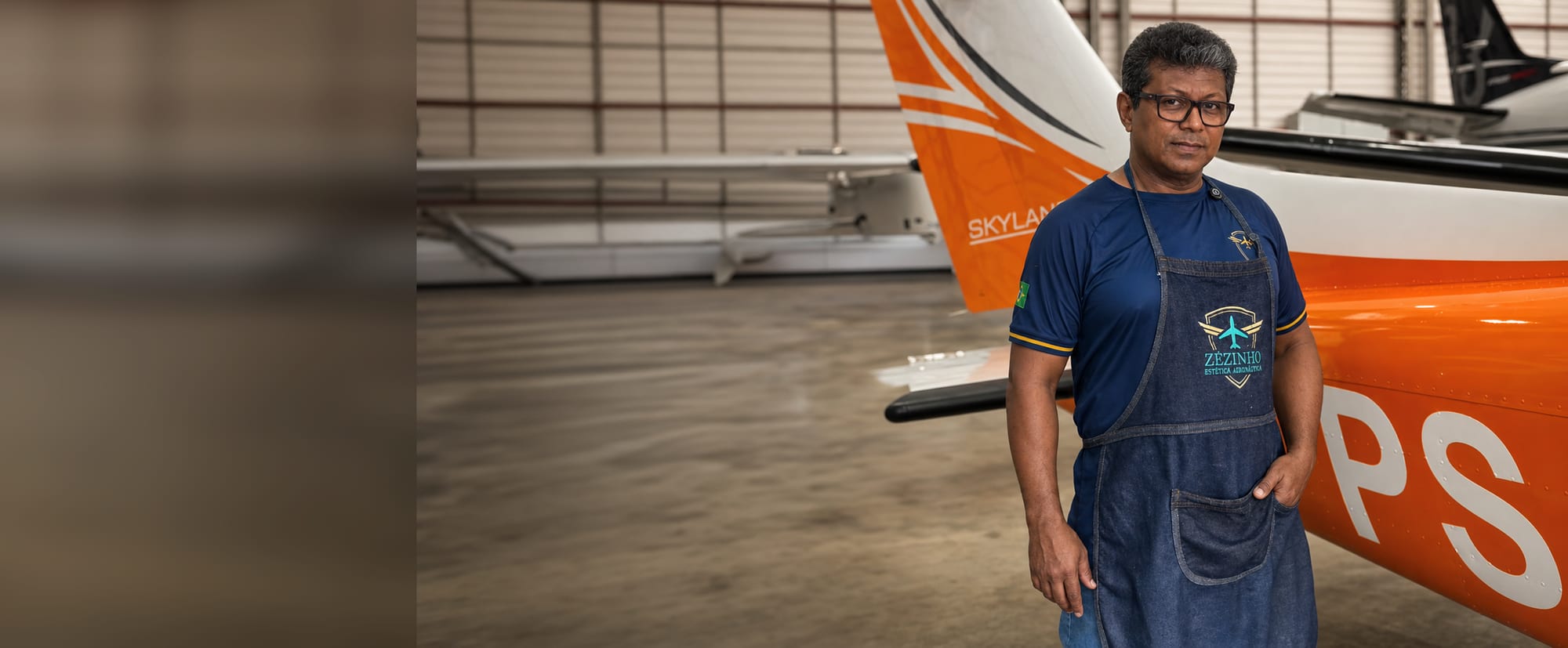Zezinho no hangar, de avental, ao lado de um Cessna Skylane